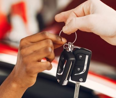 Woman buying the car. Lady in a car salon. Manager with a clients